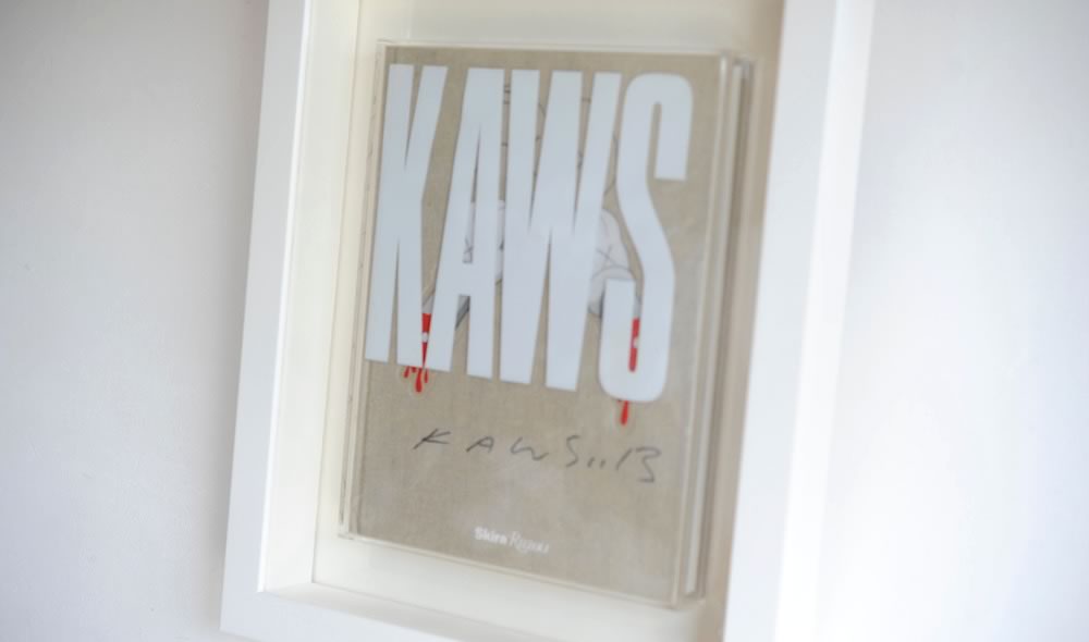 KAWS（カウズ）の作品集を額縁 Eternity Whiteで額装しています 